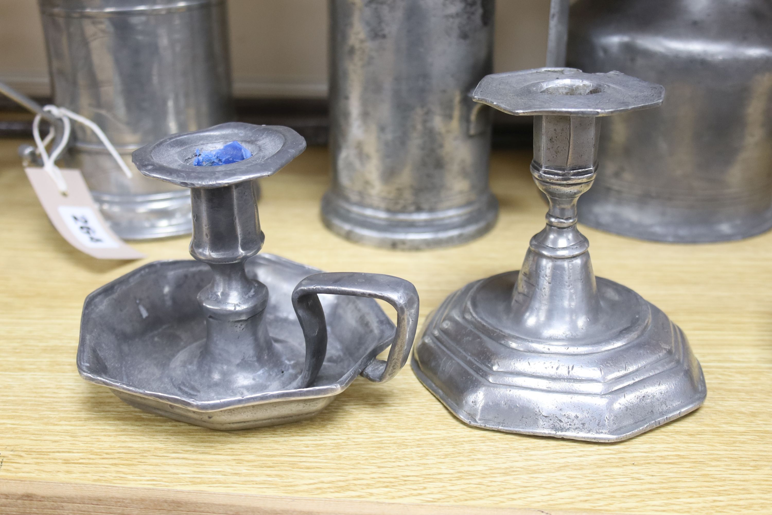 A large pair of steel dividers and a collection of 18th/19th century Continental pewter, including four various flagons, three candlesticks, a chamberstick and a porringer